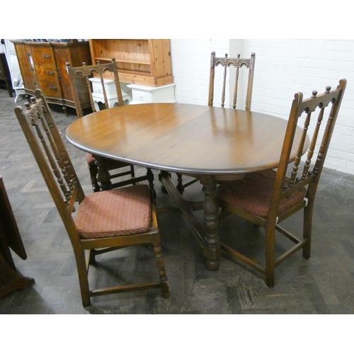 242 - An oval oak extending dining table on cross stretcher base and four high spindle back matching chair... 