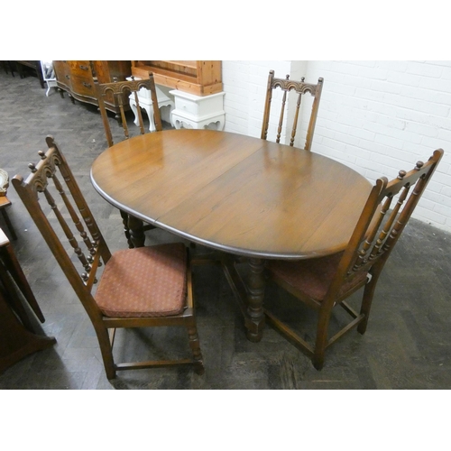 242 - An oval oak extending dining table on cross stretcher base and four high spindle back matching chair... 