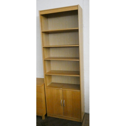 245 - A modern light oak open bookcase with cupboards under, 2'6 wide