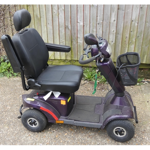 265 - A purple coloured four wheel mobility scooter in working order with charger etc