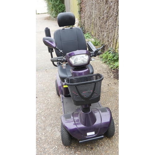 265 - A purple coloured four wheel mobility scooter in working order with charger etc