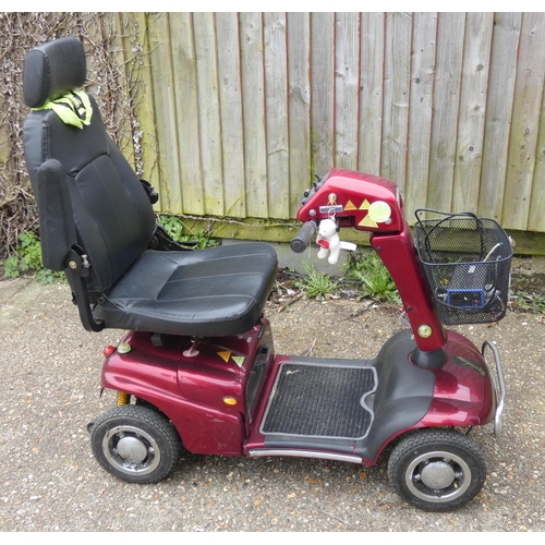 266 - A red four wheel mobility scooter in working order with charger etc