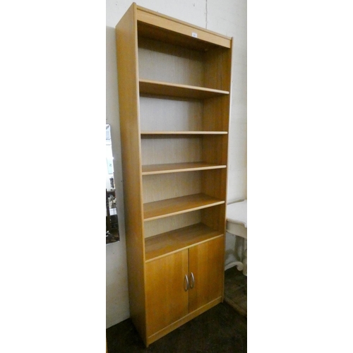 245 - A modern light oak open bookcase with cupboards under, 2'6 wide