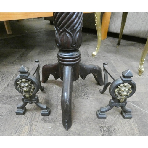 260 - A mahogany twist column torchiere and a pair of iron fire dogs