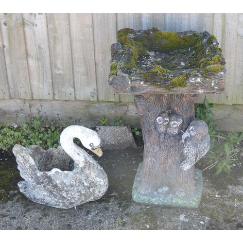 432 - A large heavy stone decorative garden birdbath with owls to the base together with a swan garden pla... 