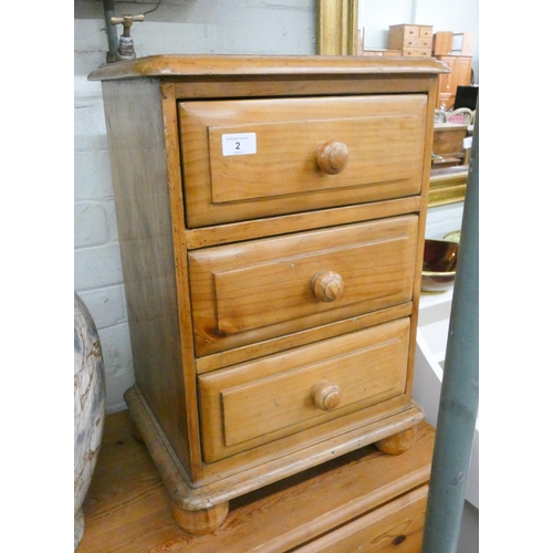 2 - A stripped and waxed pine bedside chest fitted three drawers