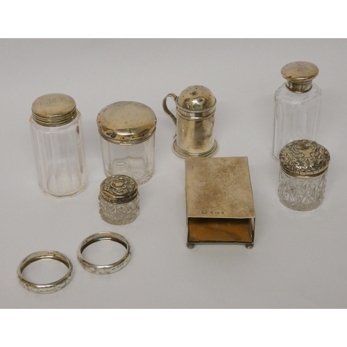 507 - A silver pepperette and a collection of silver topped dressing table jars, silver matchbox holder an... 