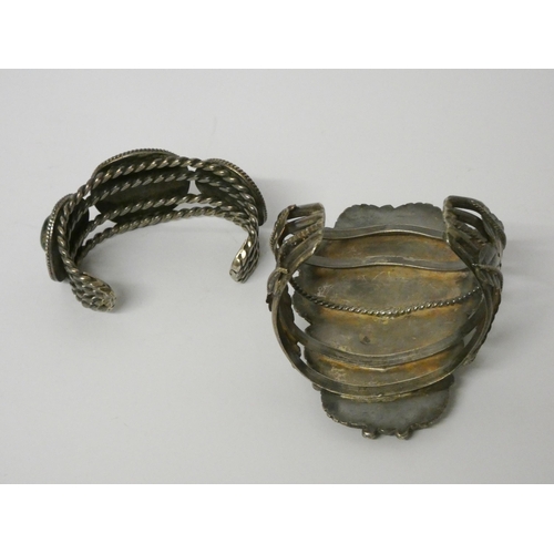 560 - A wide Indian white metal bangle, with large panel set with turquoise cabochons and a smaller simila... 