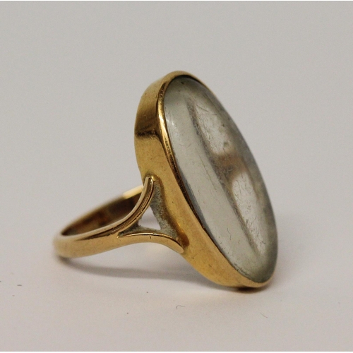 596 - Large moonstone statement dress ring, the oval stone in yellow gold rub over mount, ring size Q