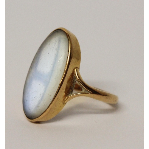 596 - Large moonstone statement dress ring, the oval stone in yellow gold rub over mount, ring size Q