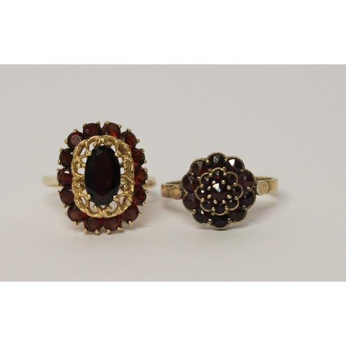 617 - An oval garnet cluster ring on 14ct yellow gold band, ring size Q, together with a circular floral d... 