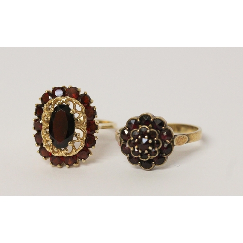 617 - An oval garnet cluster ring on 14ct yellow gold band, ring size Q, together with a circular floral d... 