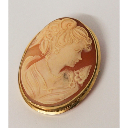 630 - An oval carved shell cameo brooch in 18ct yellow gold, marked 750. 4.8cms long