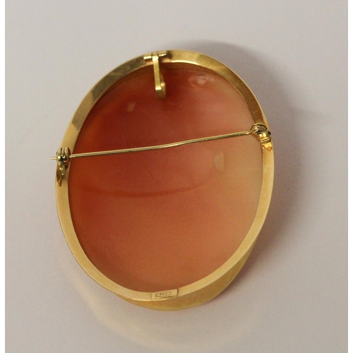 630 - An oval carved shell cameo brooch in 18ct yellow gold, marked 750. 4.8cms long