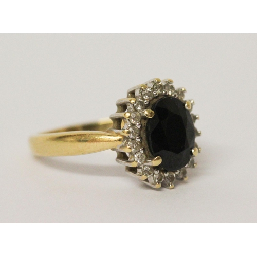 637 - An oval sapphire and diamond cluster ring, on hallmarked 18ct yellow gold band. Ring size N