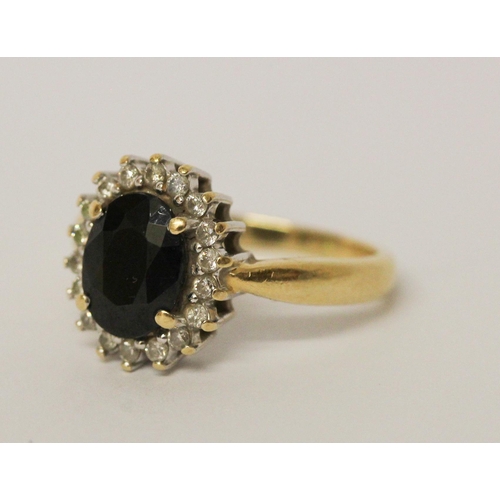 637 - An oval sapphire and diamond cluster ring, on hallmarked 18ct yellow gold band. Ring size N