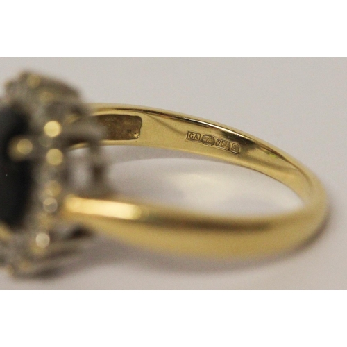 637 - An oval sapphire and diamond cluster ring, on hallmarked 18ct yellow gold band. Ring size N