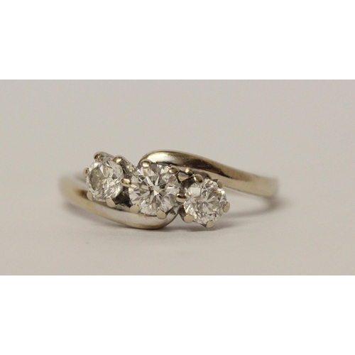 627 - A three stone diamond ring in cross over design setting, hallmarked 18ct white gold band. Ring size ... 