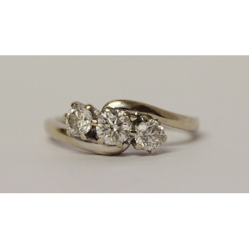 627 - A three stone diamond ring in cross over design setting, hallmarked 18ct white gold band. Ring size ... 