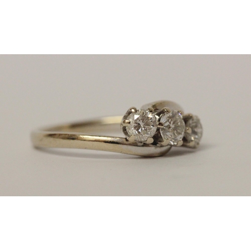 627 - A three stone diamond ring in cross over design setting, hallmarked 18ct white gold band. Ring size ... 