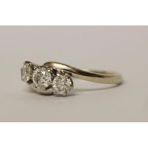 627 - A three stone diamond ring in cross over design setting, hallmarked 18ct white gold band. Ring size ... 