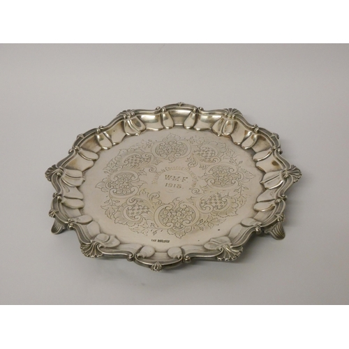 684 - A silver card waiter of small salver, with decorative cast shell border, engraved with presentation ... 