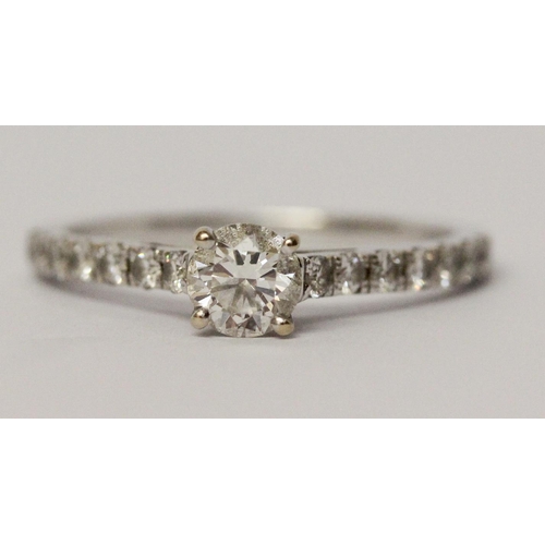 545 - A modern diamond engagement ring, with a circular brilliant cut diamond in claw setting on brilliant... 