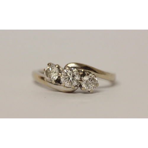 627 - A three stone diamond ring in cross over design setting, hallmarked 18ct white gold band. Ring size ... 