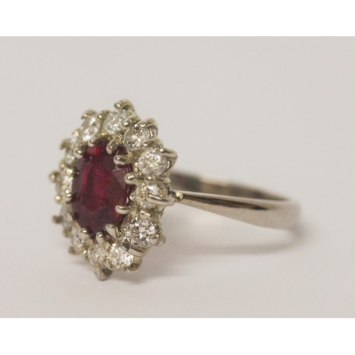 658 - A large ruby and diamond oval cluster ring, the ruby weighing approximately 1.5 carats and diamonds ... 