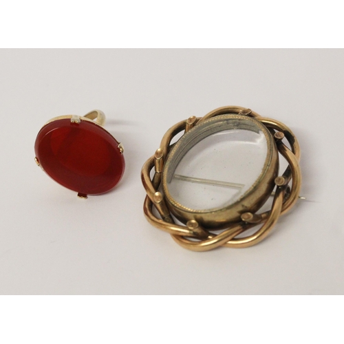 455 - A large carnelian hard stone set ring in claw setting and a Victorian glazed oval locket in yellow m... 