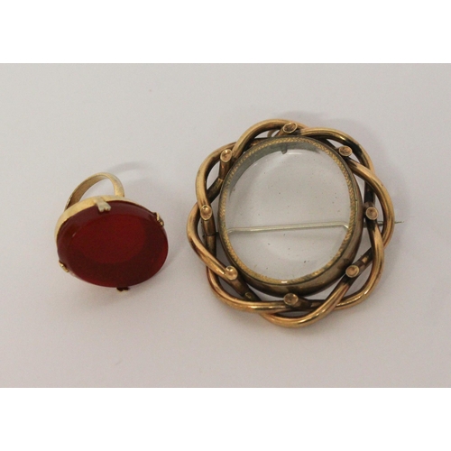 455 - A large carnelian hard stone set ring in claw setting and a Victorian glazed oval locket in yellow m... 