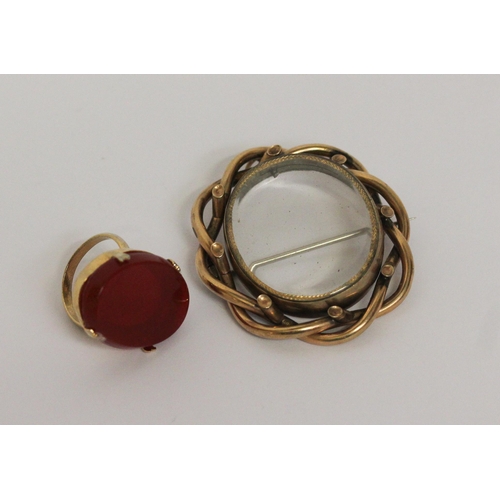 455 - A large carnelian hard stone set ring in claw setting and a Victorian glazed oval locket in yellow m... 