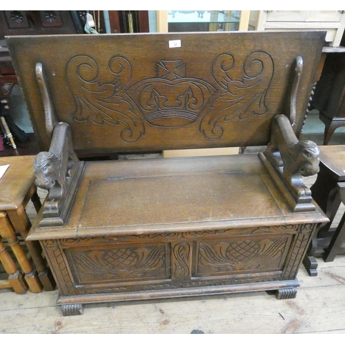 37 - A carved oak Monks bench with fold over top and lion ends, 3'6 wide