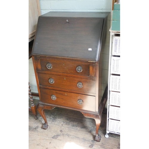 48 - A ladies dark mahogany bureau with three drawers under standing on claw and ball feet