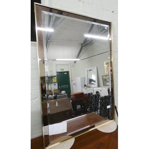 90 - A modern bevelled wall mirror with smoked glass frame