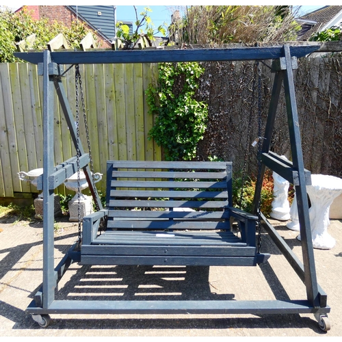 807 - A large heavy dark grey painted wooden garden swing on wheels