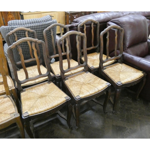 210 - A set of six French oak dining chairs with rush seats on cabriole legs with cross stretchers