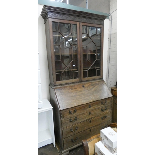 235 - A Georgian mahogany bureau bookcase with glazed lattice doors, four long drawers under, with fitted ... 