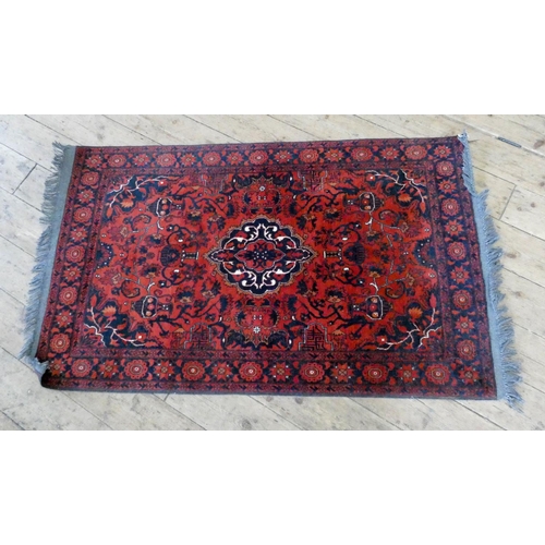 274 - A red and patterned Persian rug, 5'6 x 3'3