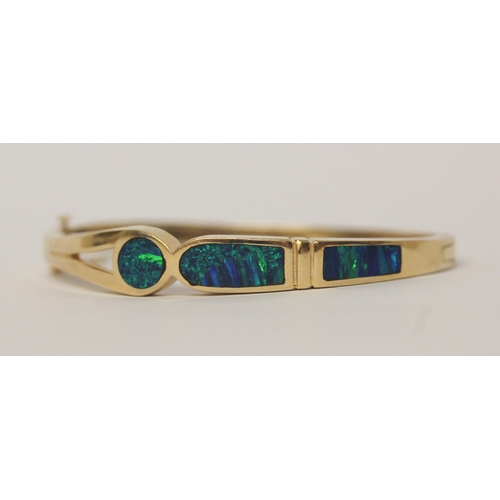 486 - A modern 14k yellow gold opal set hinged bangle, marked 14k,  gross weight 26.7 g