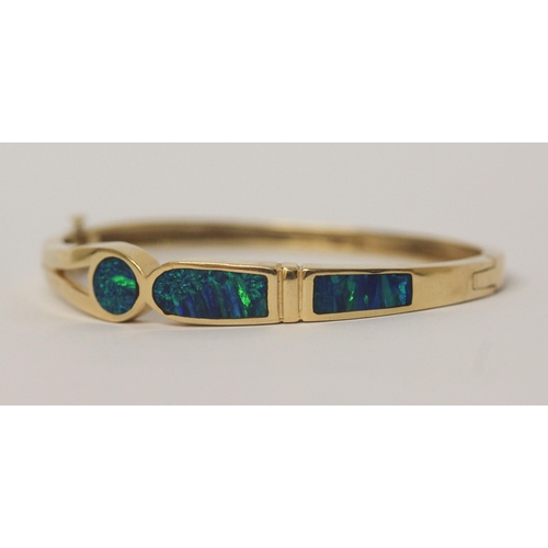 486 - A modern 14k yellow gold opal set hinged bangle, marked 14k,  gross weight 26.7 g