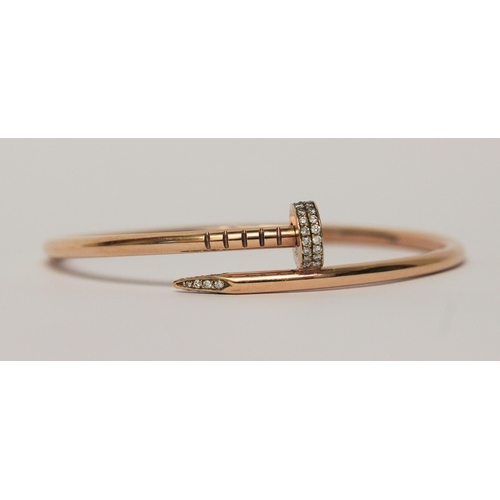 505 - In the style of Cartier Juste un clou rose gold bangle, set with diamonds. 14ct rose gold marked 'Ca... 