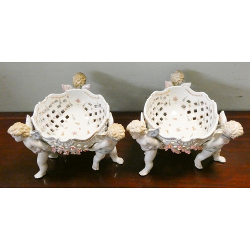 187 - Large pair matching Dresden style pierced centrepiece bowls supported by cherubs, 22cms tall