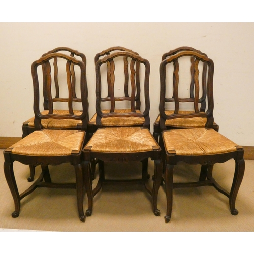 210 - A set of six French oak dining chairs with rush seats on cabriole legs with cross stretchers