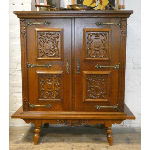 234 - A French oak two door cabinet with four carved fielded panels to the doors, shelves inside, standing... 