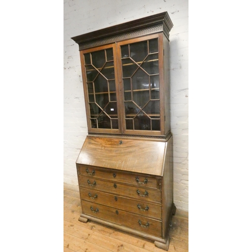 235 - A Georgian mahogany bureau bookcase with glazed lattice doors, four long drawers under, with fitted ... 