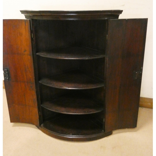 263 - A Georgian shell inlaid mahogany bow front hanging corner cupboard, fitted two doors with interior s... 