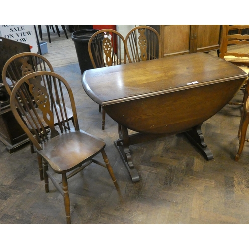 314 - A circular Ercol oak drop leaf dining table on refectory style base, 3'9 wide and four wheel back Wi... 