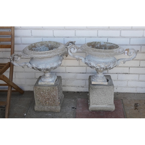 802 - A pair of light metal urn shaped garden planters on a concrete base