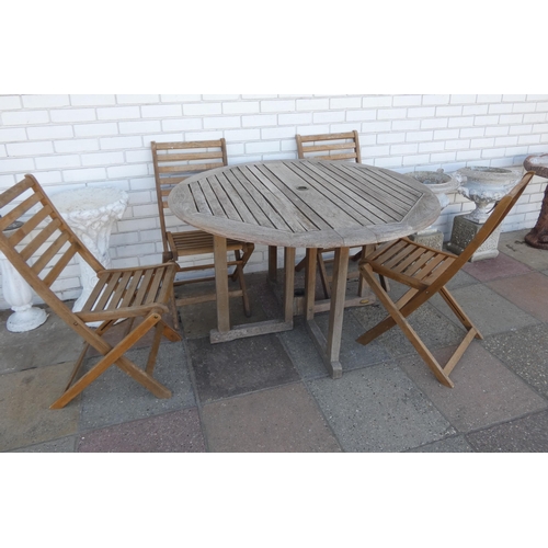 806 - A circular folding hardwood garden table with four hardwood folding chairs